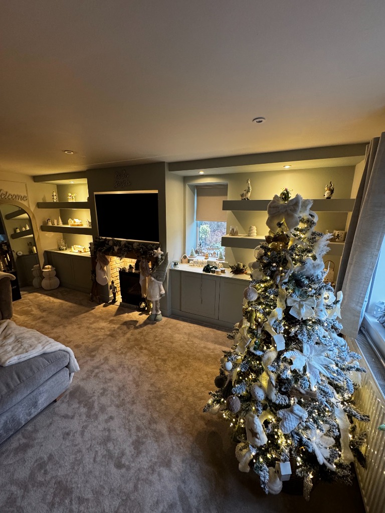 Custom living room media wall with built-in cabinetry, floating shelves, and a cozy fireplace